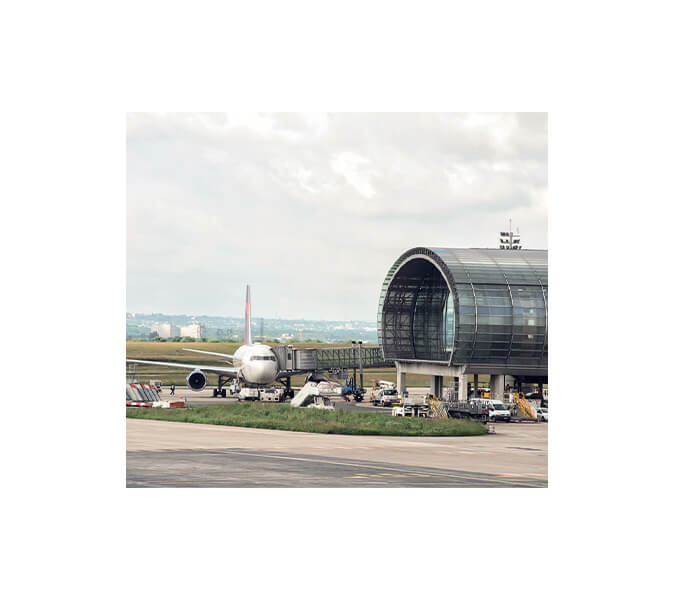 Bild eines am Boden liegenden Flugzeugs mit einem Teil des Flughafengebäudes am Airport Paris-Charles-de-Gaulle.