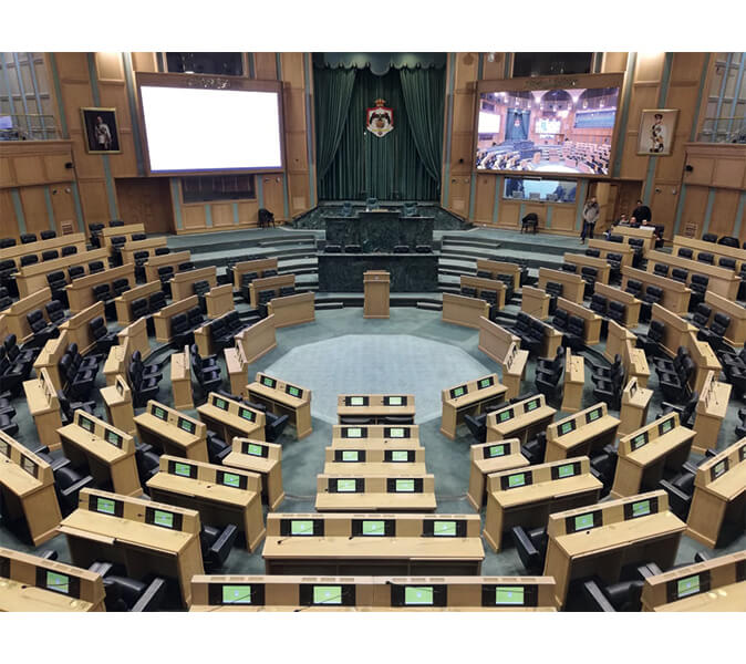 Team of the Jordanian distributor Parliament Hall of Jordan, in the background a line array speaker in column design with Beam Steering technology.