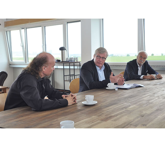 CEO Udo Borgmann, Lower Saxony's Minister of Economic Affairs Bernd Althusmann and Helmut Streiff, President of the Braunschweig Chamber of Industry and Commerce, talk at the conference table in the new Pan Acoustics GmbH building. 