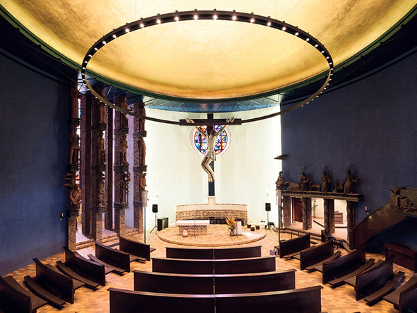 View from the end of the church hall in St. Boniface to the chancel, where a figure of Jesus on a wooden cross makes up the centre.  