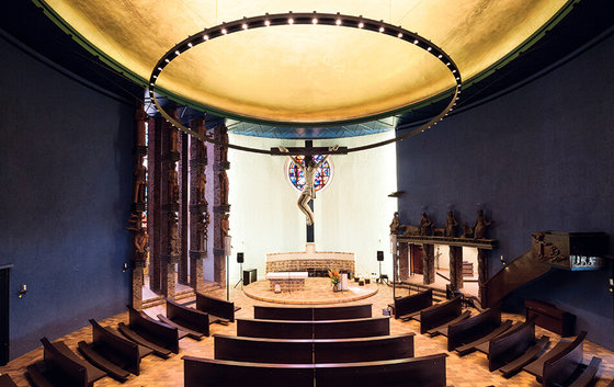 View from the end of the church hall in St. Boniface to the chancel, where a figure of Jesus on a wooden cross makes up the centre.  