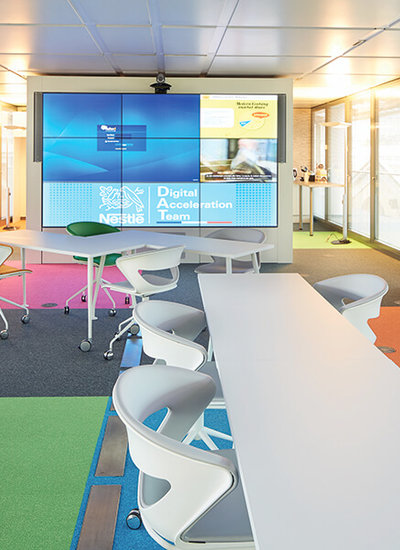 Line array speakers in Nestle's colourful meeting room create speech intelligibility despite sound-reflecting glass walls